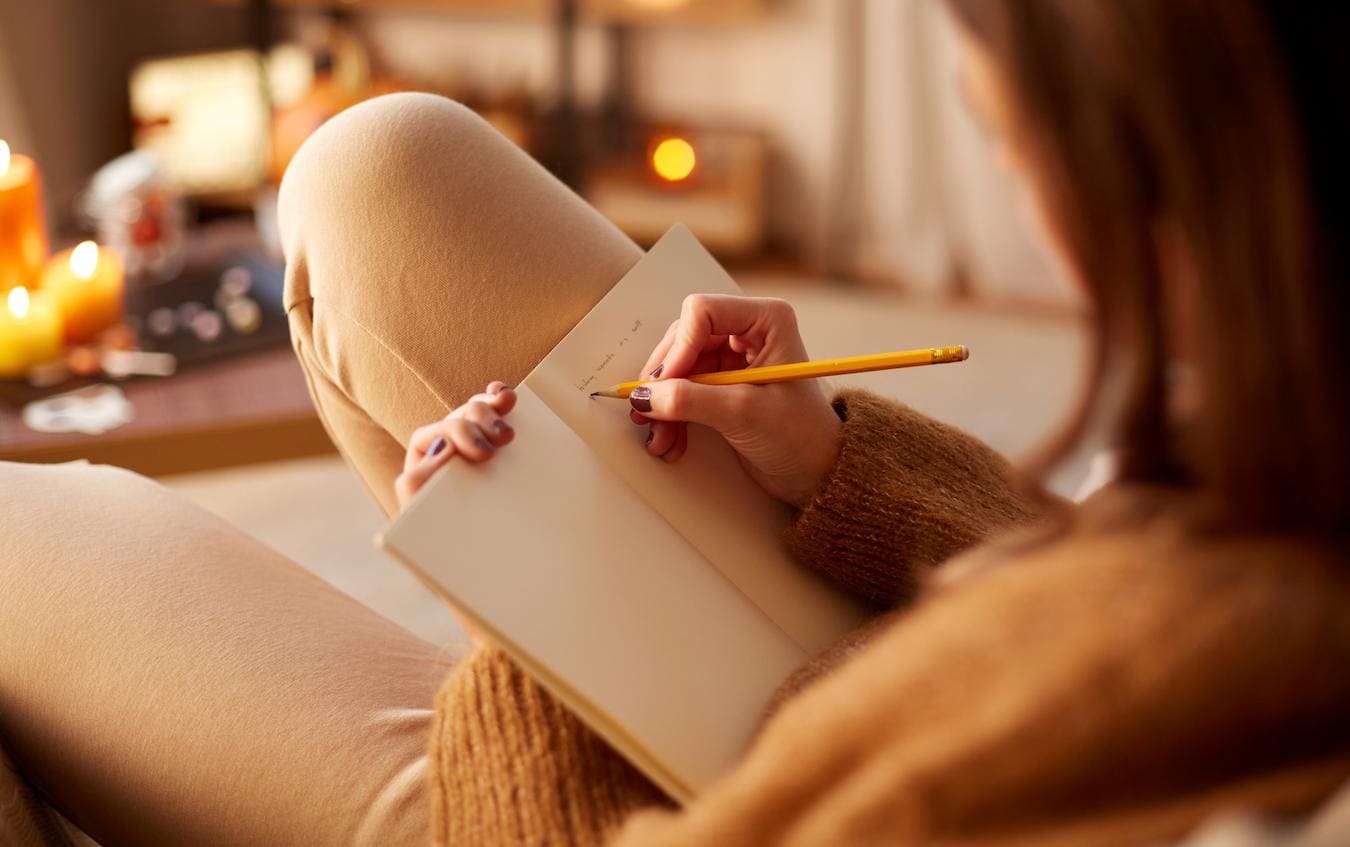 a girl writing in a notebook team building event promotional items fitness gear custom swag boxes create swag custom jackets