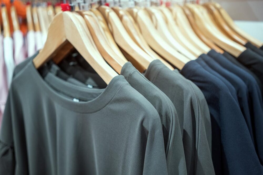 clothes on a rack in a store sub brand guidelines wearing merch print on demand partner t shirt featuring create engaging visuals promote your merch own catalog